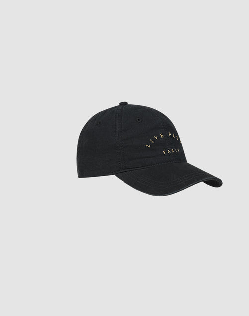 The Live Fast Paris Cap by LIVE FAST DIE YOUNG is a black 100% Baumwolle baseball cap with a curved brim and yellow "LIVE FAST PARIS" embroidery on the front, shown against a plain light gray background.