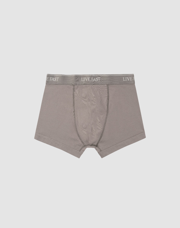 LIVE FAST DIE YOUNGās Live Fast Trunks (2 Pack) feature soft gray cotton, a visible front pouch, and an elastic waistband with repeated LIVE FAST branding. Displayed flat on a light gray background. Care instructions included.