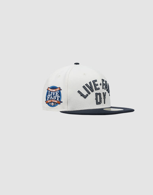 The LFDY X NEW ERA 59FIFTY by LIVE FAST DIE YOUNG features a classic white fitted design with a dark blue brim, bold black LIVE FAST embroidery on the front, and a blue, white & orange side patch. See the Größentabelle for sizing.