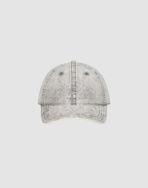 The LIVE FAST DIE YOUNG Live Fast Paris Cap is a light grey, distressed 100% Baumwolle baseball cap in Sunfade Optik with white "LIV FAST PARIS" embroidery, visible stitching, and a Metallschnalle, shown on a plain light background.