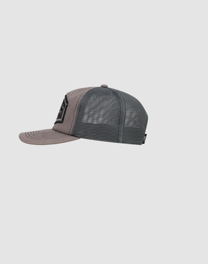 Side view of the gray LFDY Rivet Trucker cap by LIVE FAST DIE YOUNG, with a mesh back, solid front panel, slightly curved brim, and a black Flag-Label tag on the mesh. Set against a plain light gray background.