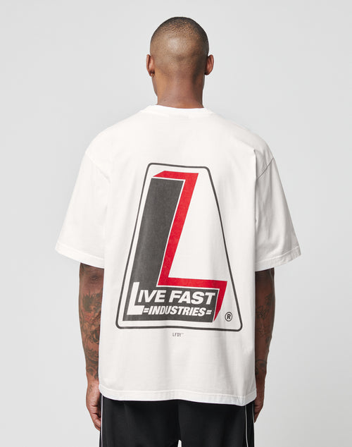 A person with short hair, seen from behind, wears an oversize white LIVE FAST DIE YOUNG LFDY Industries Tee (100% Baumwolle), featuring a large red and black L graphic and LIVE FAST INDUSTRIES text on the back (LF2406-15692).