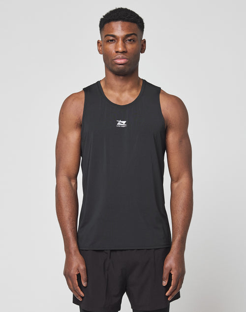 A man faces forward against a plain light background wearing the LIVE FAST DIE YOUNG Live Fast Performance Tank in slim fit black nylon spandex, paired with matching black shorts.