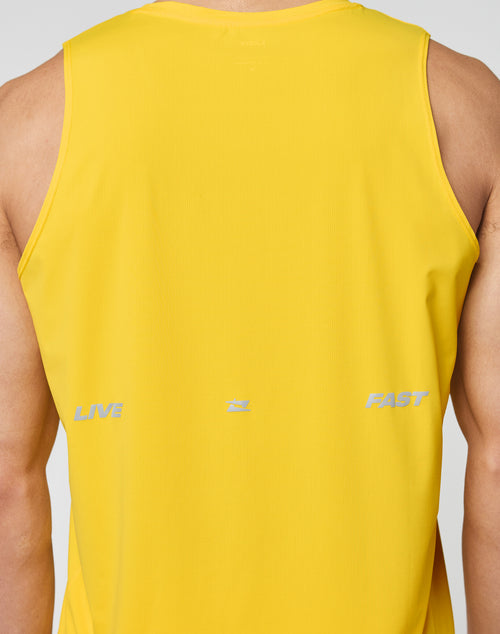 A person wearing the LIVE FAST DIE YOUNG Live Fast Performance Tank—a slim fit, sleeveless yellow nylon-spandex athletic shirt—shown from the back with LIVE and FAST in light gray and a subtle reflective print.