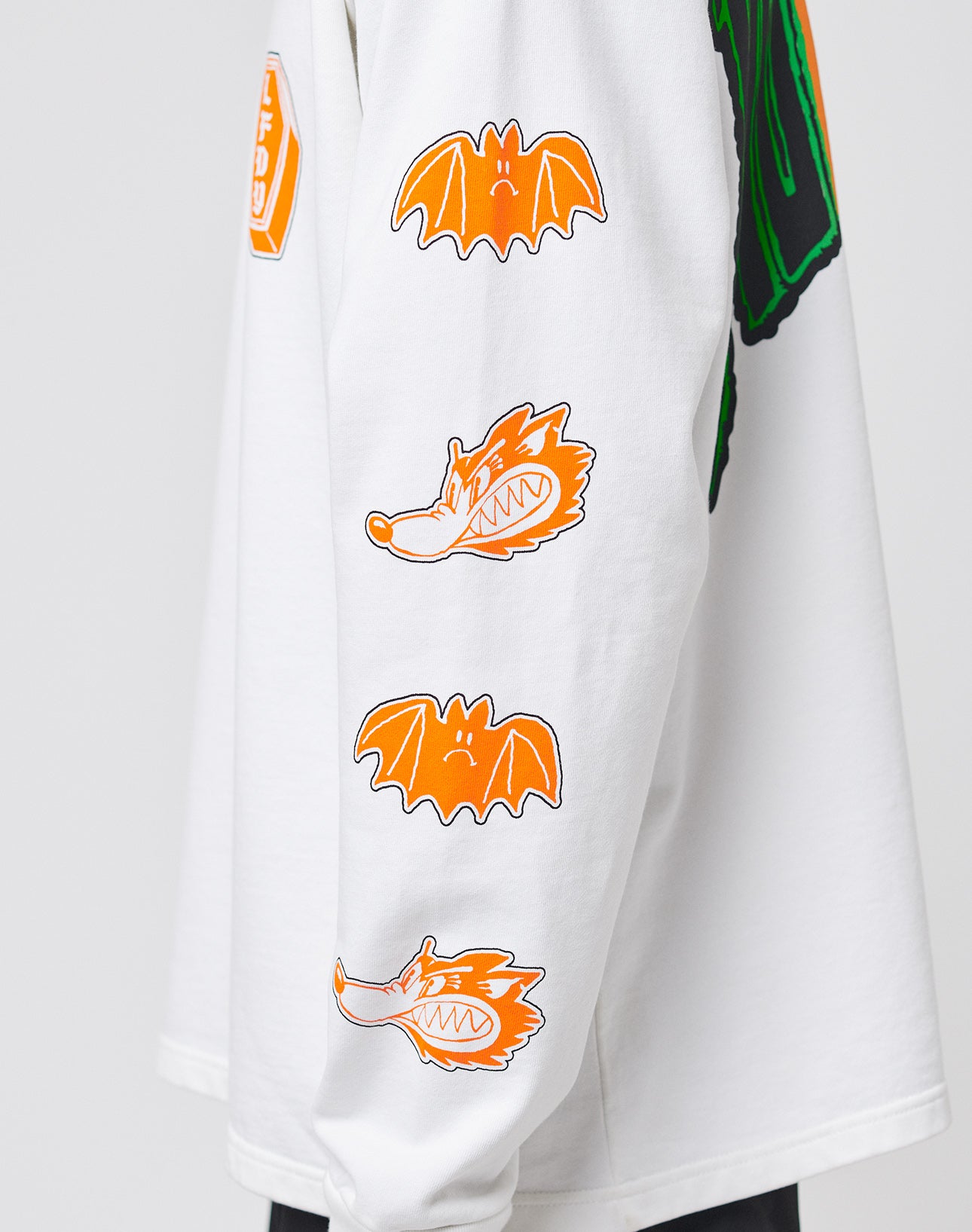 The LIVE FAST DIE YOUNG No Rich Parents Longsleeve is a regular-fit, white shirt made from 100% Baumwolle, with orange cartoon bats and playful wolf heads printed along the sleeves.