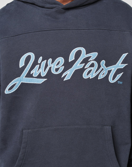The LFDY Script Hooded by LIVE FAST DIE YOUNG is a navy blue oversized hoodie featuring Live Fast in large, light blue cursive across the chest.