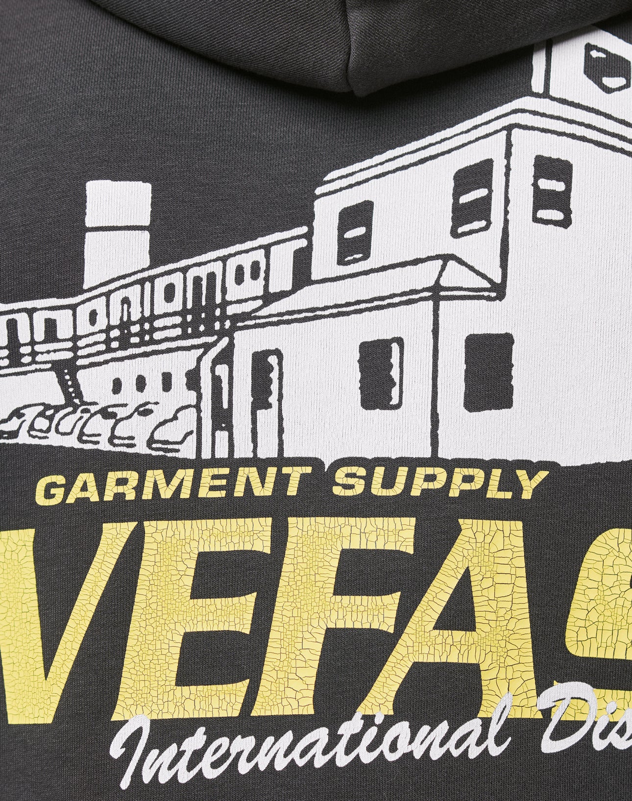 Close-up of the LFDY Supply Hooded by LIVE FAST DIE YOUNGāa black, oversized hoodie with a discharge print of white buildings, yellow cracked VEFAS text, smaller GARMENT SUPPLY International Dis. details, in soft Baumwolle Polyester blend.