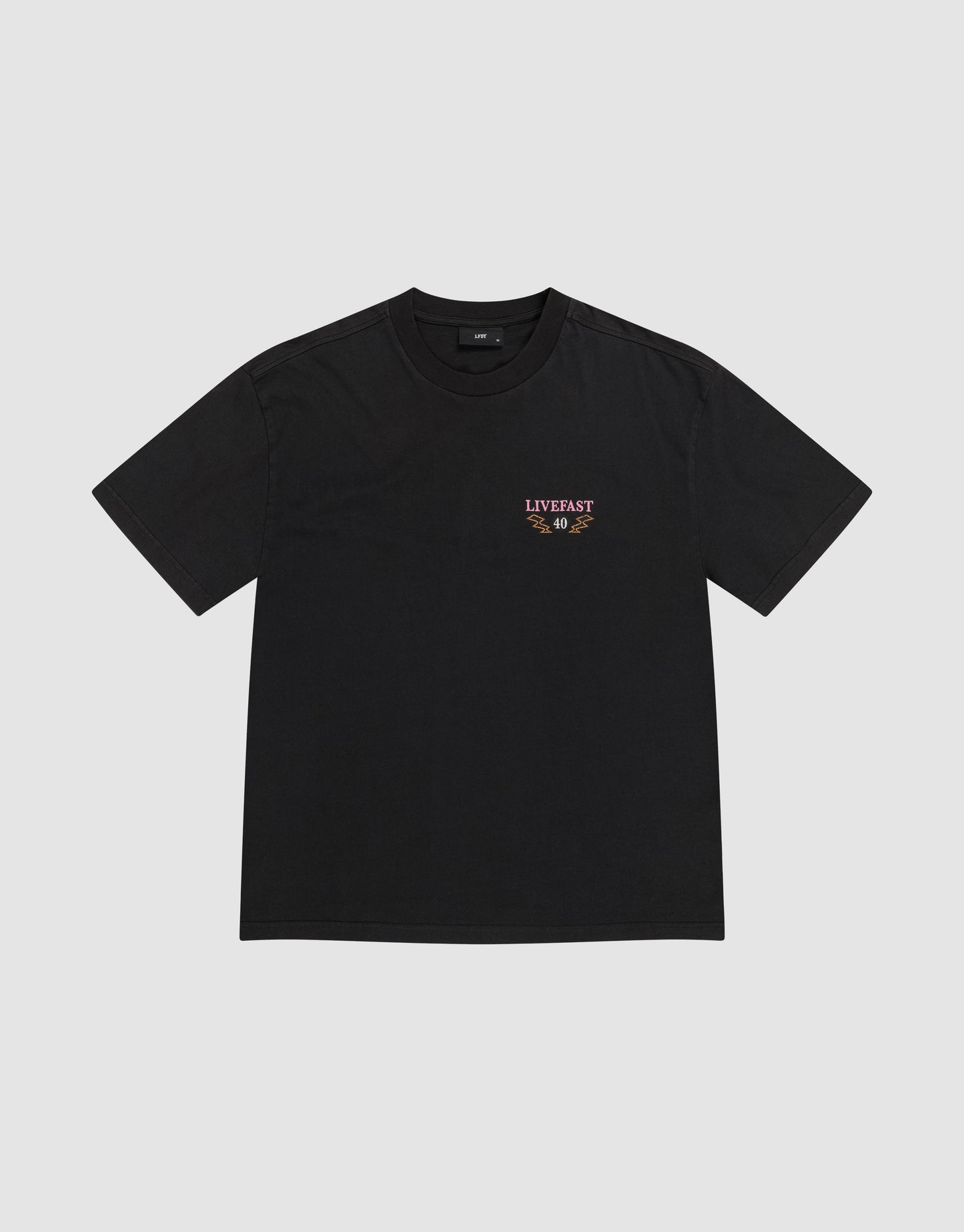 The LFDY Under Fire Tee by LIVE FAST DIE YOUNG is a black Oversize Fit T-shirt made from 100% cotton, featuring a small LIVEFAST text and orange-white graphic on the left chest, shown on a light gray background.