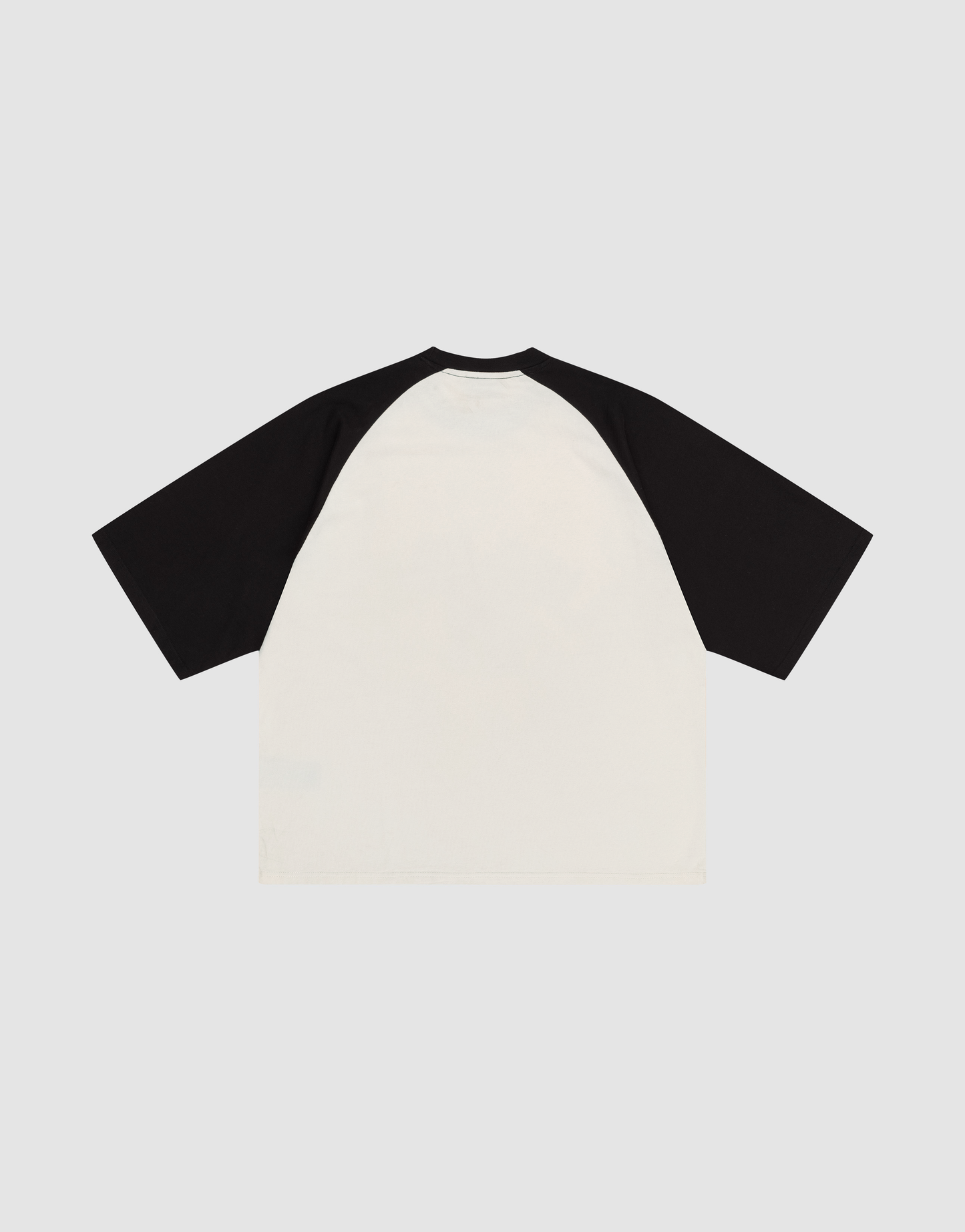 The Live Fast Raglan Tee by LIVE FAST DIE YOUNG features black raglan sleeves, a white 100% cotton body, and is shown laid flat with the back up on a light gray background.