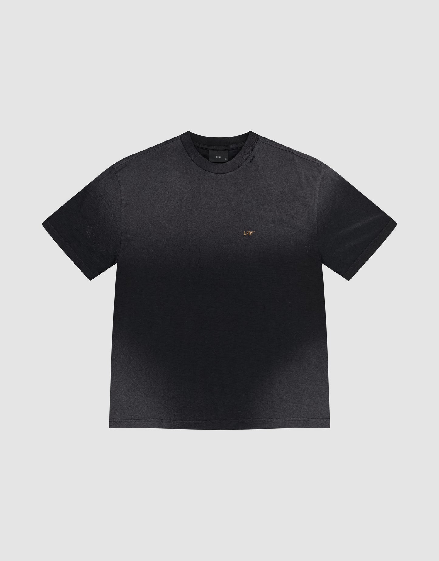 The LFDY Hinterhof Tee by LIVE FAST DIE YOUNG is a black cotton-slub short-sleeve t-shirt featuring a subtle gradient and small gold "LIFT" lettering on the left chest, shown against a plain light gray background.