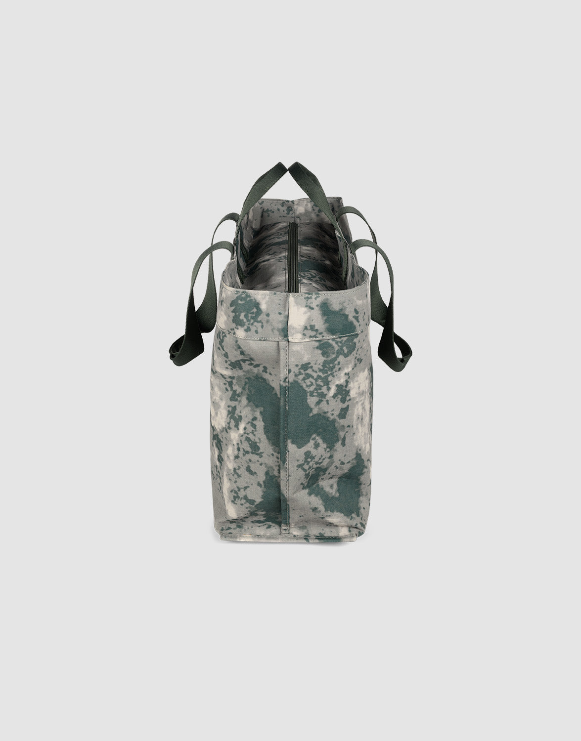 The LFDY Utility Bag by LIVE FAST DIE YOUNG features a gray-green camo pattern, black straps, zippered top, and spacious compartment—ideal as a laptop tote—shown upright against a plain light gray background.