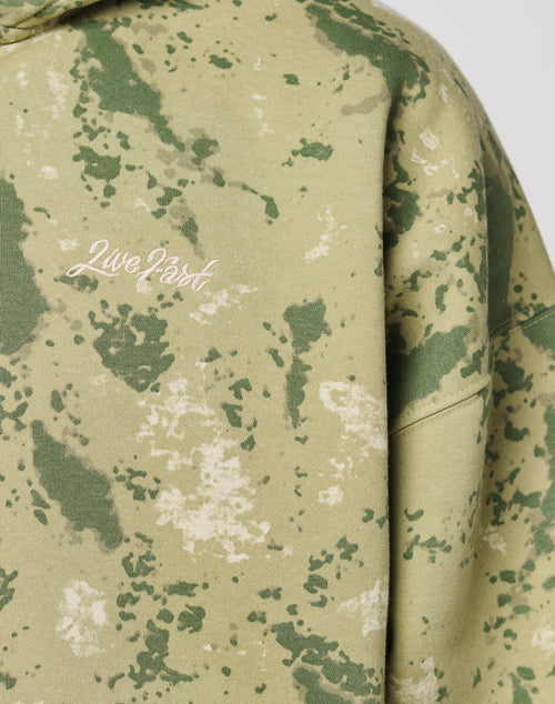 Close-up of the LIVE FAST DIE YOUNG Camo Hooded Zip in green and beige camouflage Oversize Fit, featuring Live Fast embroidered in white on the chest.