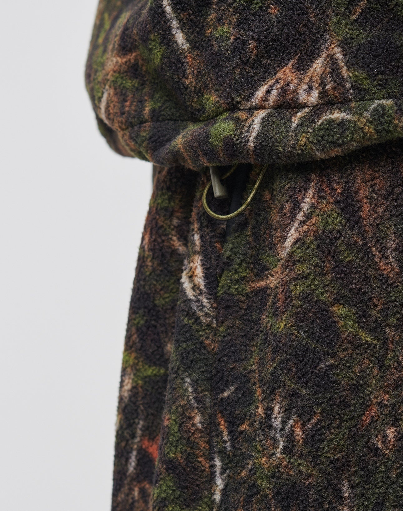 Close-up of the LFDY Fleece Hooded Zip by LIVE FAST DIE YOUNG, crafted from thick, soft textured fleece in a green, brown, and black camo pattern with a metal loop detail and an oversized fit.