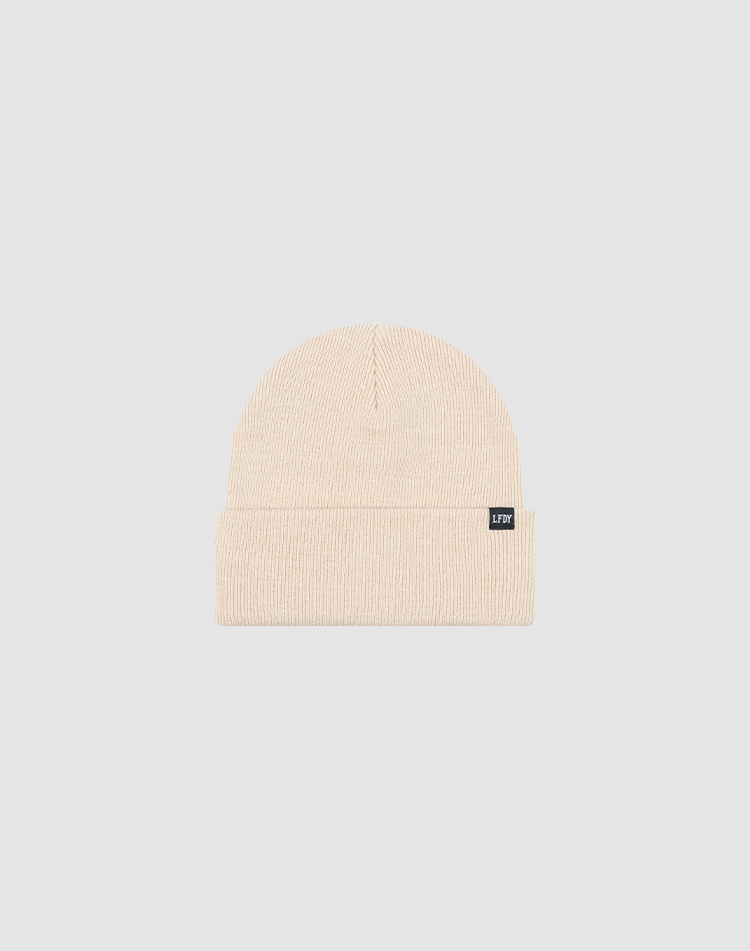The LIVE FAST DIE YOUNG Basic Beanie in beige, One Size, features a folded brim and a small rectangular black Flag-Label on the cuff, shown on a light gray background.