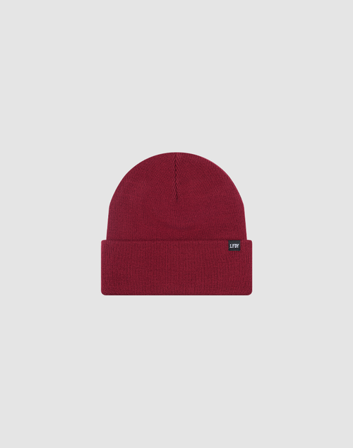 The LIVE FAST DIE YOUNG Basic Beanie is a plain, deep red, One Size knit with a folded brim and small black flag label on the front, shown on a light gray background. Made from 100% Polyamid for comfort and durability.