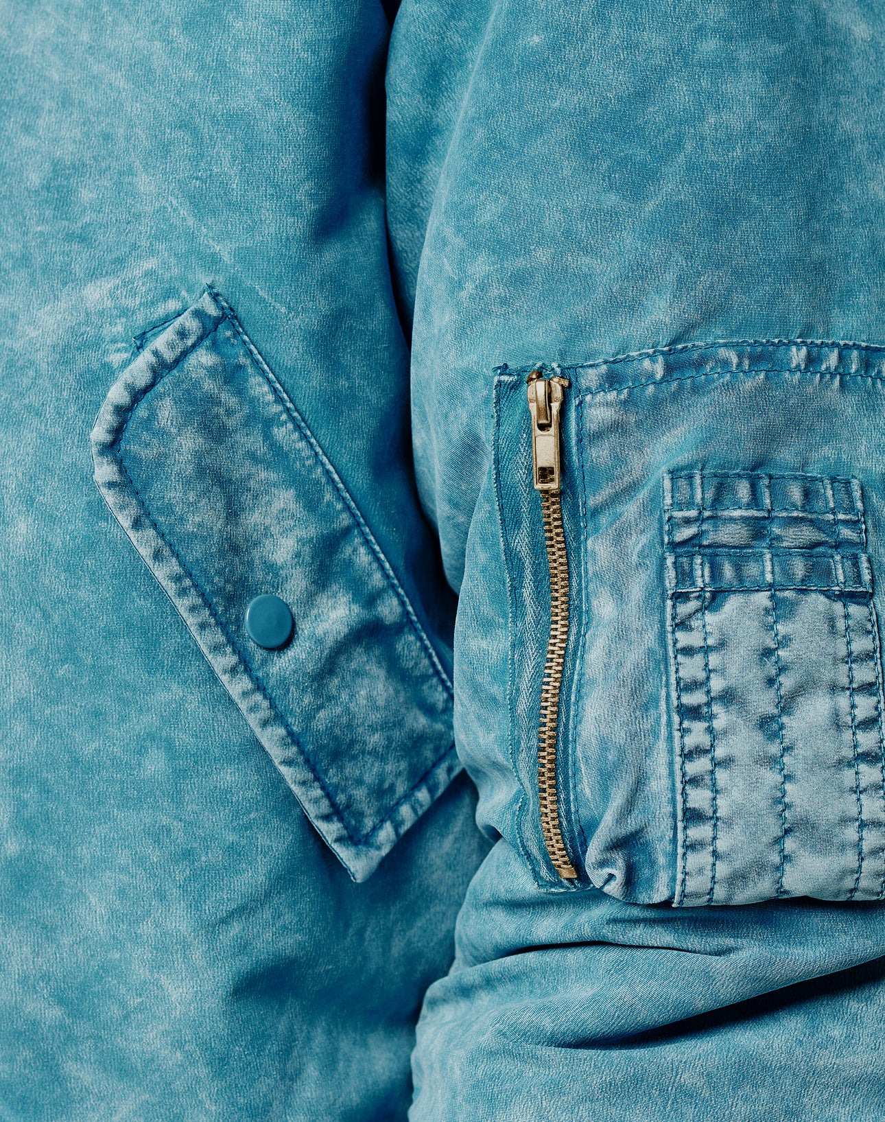 Close-up of the Washed Bomber Jacket by LIVE FAST DIE YOUNG: light blue denim sleeve features a snap-button flap pocket, zippered pocket, and visible stitching. Regular Fit for comfort and style.