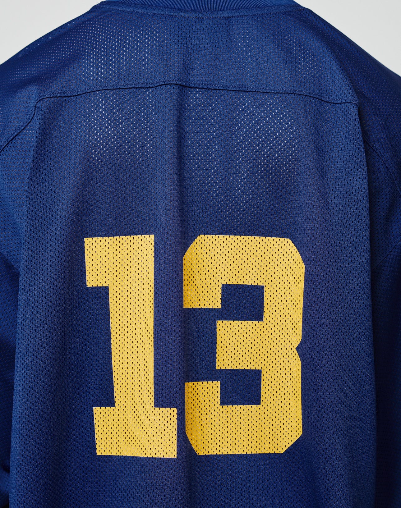 A close-up of the back of the blue LIVE FAST DIE YOUNG LFDY Mesh Jersey, featuring an oversize fit and the number 13 in large yellow print.