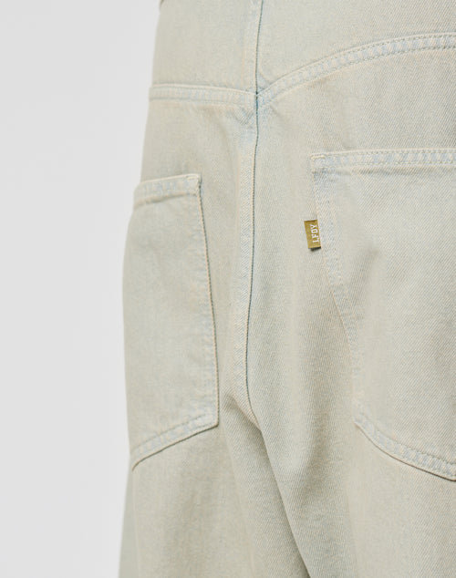 Close-up of the LIVE FAST DIE YOUNG LFDY Baggy Denim shows two back pockets, a gold-tone flag-label on the right pocket, and visible seams and stitching on light-colored baggy-fit jeans.