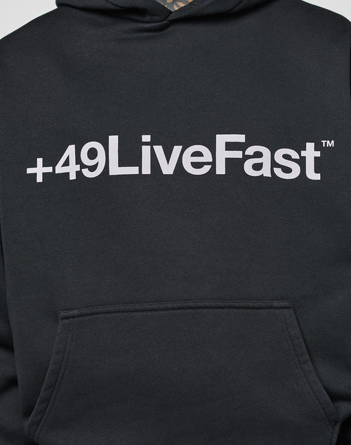 The Basic +49 Hooded by LIVE FAST DIE YOUNG is a black, oversized hoodie with a bold white +49LiveFast™ front print above the pocket, made from a soft cotton-polyester blend.