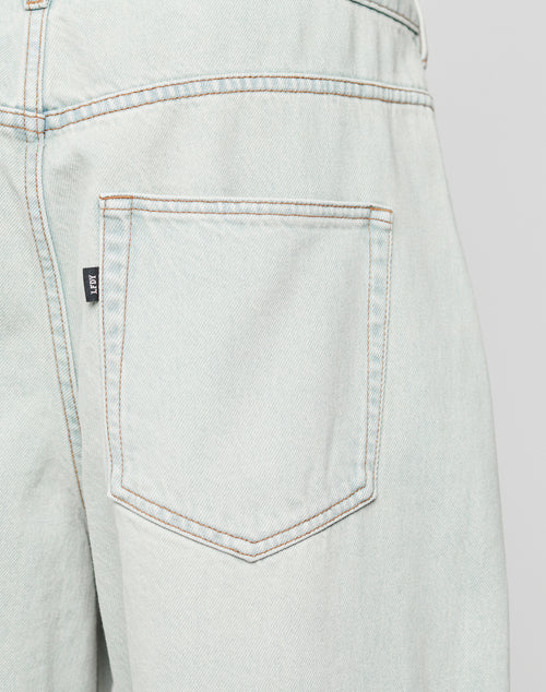 Close-up of the back pocket on LFDY Baggy Denim by LIVE FAST DIE YOUNG, showing a Flag-Label at the side seam, brown stitching, and slightly faded Baumwolle fabric for classic character.