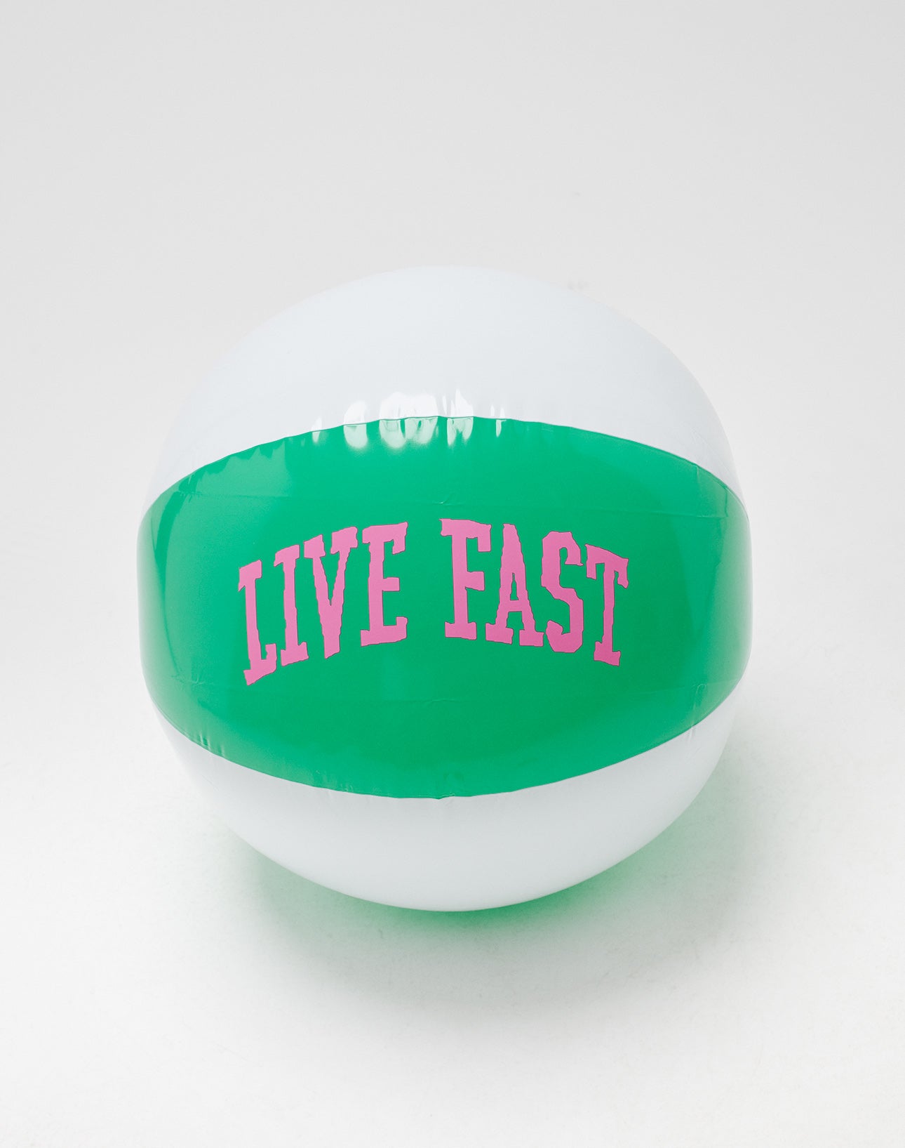The LFDY Beach Ball by LIVE FAST DIE YOUNG is white and green, featuring LIVE FAST in pink neon-style letters on the green stripe, shown against a plain white background.
