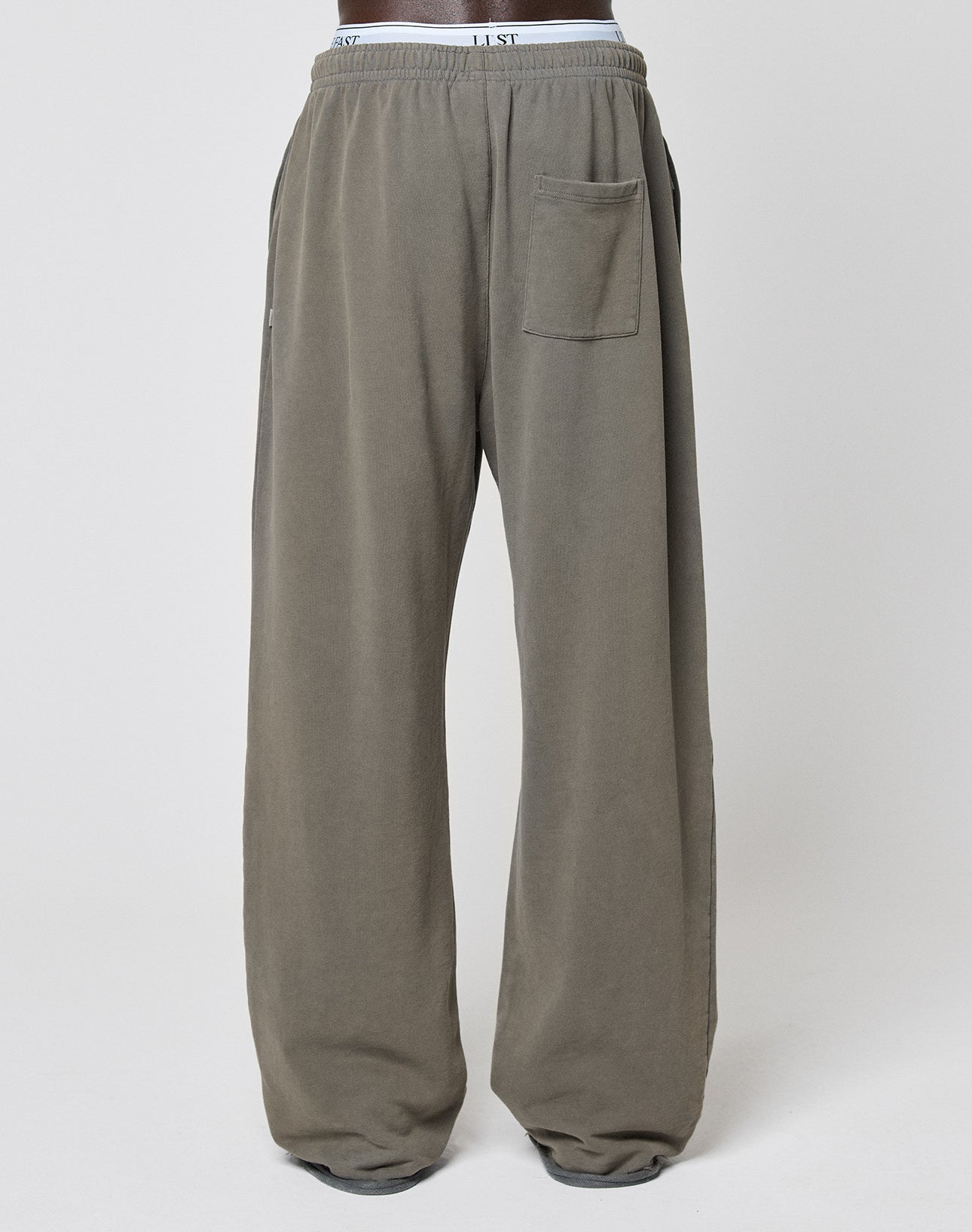 The LFDY Ripped Sweatpants by LIVE FAST DIE YOUNG are wide-fit, loose gray sweatpants made from 100% Baumwolle, with an Elastikbund, side and back pockets, plus a visible branded waistband, shown against a plain white background.