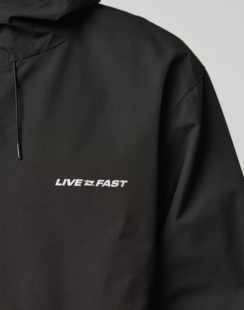 A close-up of the Basic Shell Jacket by LIVE FAST DIE YOUNG featuring reflektierender Druck: the words LIVE FAST and a small airplane graphic on the left chest area.