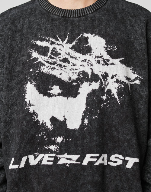 The LFDY Savior Knit Sweater by LIVE FAST DIE YOUNG features a vintage-wash dark knit, white abstract dog and tree graphic, bold LIVE FAST lettering, and is made from 100% Baumwolle for comfortable wear.
