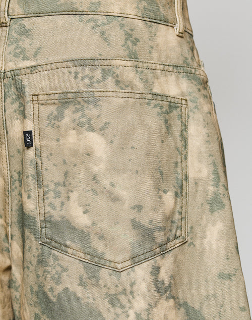 Close-up of the back pocket on LIVE FAST DIE YOUNG Canvas Shorts. Features visible stitching, a baggy fit, a small black tag on the pocket, and is made from 100% cotton.