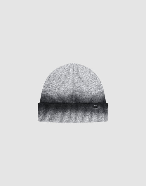 The LIVE FAST DIE YOUNG "Live Fast Boucle Beanie" is a gray knitted hat with a folded brim, subtle Sprayeffekt gradient from light to dark gray, and a discreet Flag-Label, shown against a plain light background.