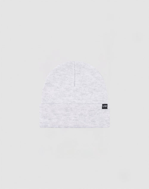 The LIVE FAST DIE YOUNG Basic Beanie is a light gray Polyacryl knit, one size, with a folded cuff and a small black rectangular flaglabel with white text on the cuff, shown against a plain light background.