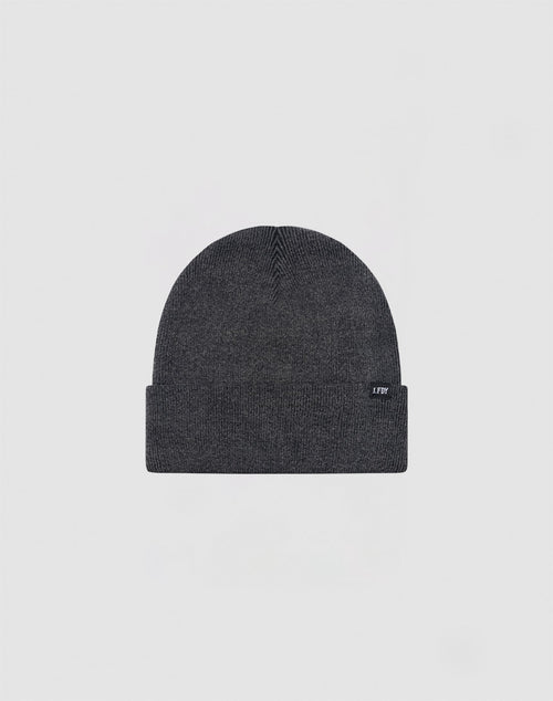 The LIVE FAST DIE YOUNG Basic Beanie is a dark gray cotton hat with a folded brim and a small rectangular tag on the left side, shown on a light gray background. Care instructions are provided for easy maintenance.