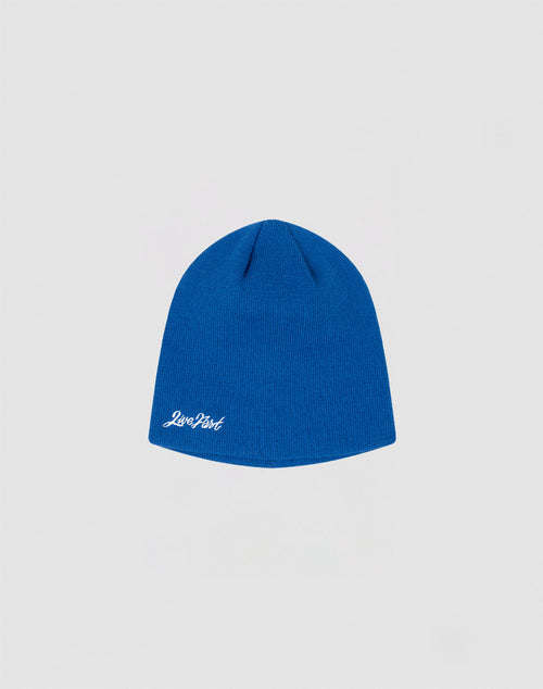 A blue Script Beanie by LIVE FAST DIE YOUNG features a small white Zero Dark logo-stitch on the lower edge, displayed against a light gray background.