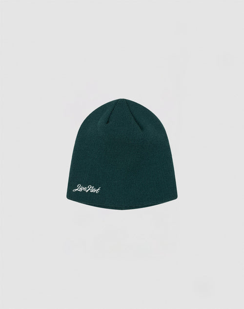 A dark green Script Beanie by LIVE FAST DIE YOUNG, featuring a small white Just Past logo on the front, displayed against a plain light gray background.