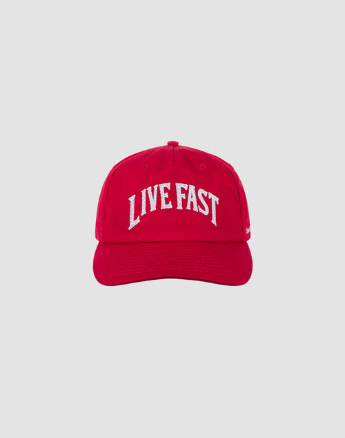The Live Fast Unstructured Cap by LIVE FAST DIE YOUNG features bold white LIVE FAST text and a Logo-Stick on a red cap with Mit Snapverschluss for easy adjustment. Photographed against a plain light gray background. One size fits most.