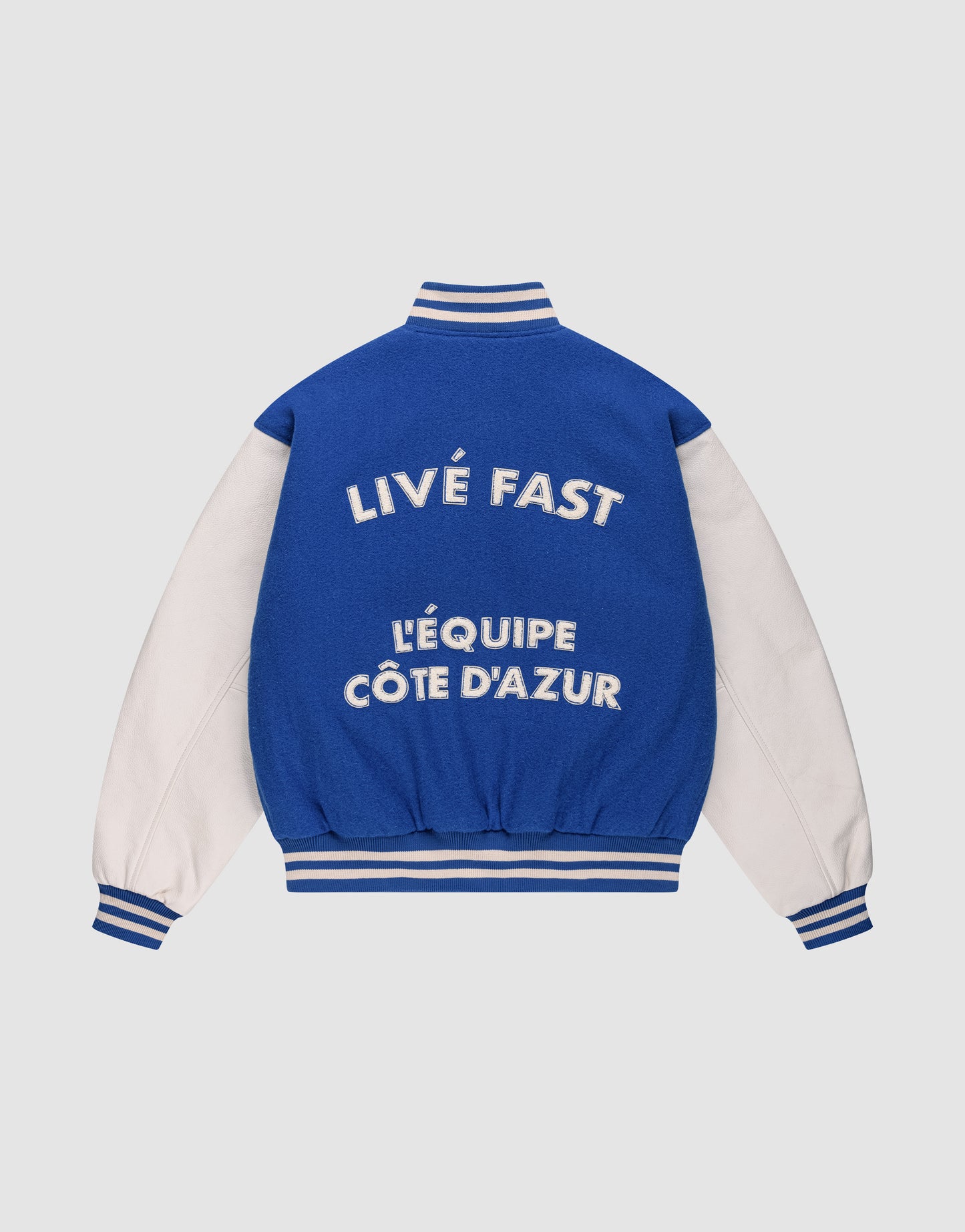 The LIVE FAST DIE YOUNG LFDY x Schott NYC Varsity Jacket features blue and white coloring, striped cuffs and collar, bold white back text, and premium chenille patches for a standout look. Limited edition.