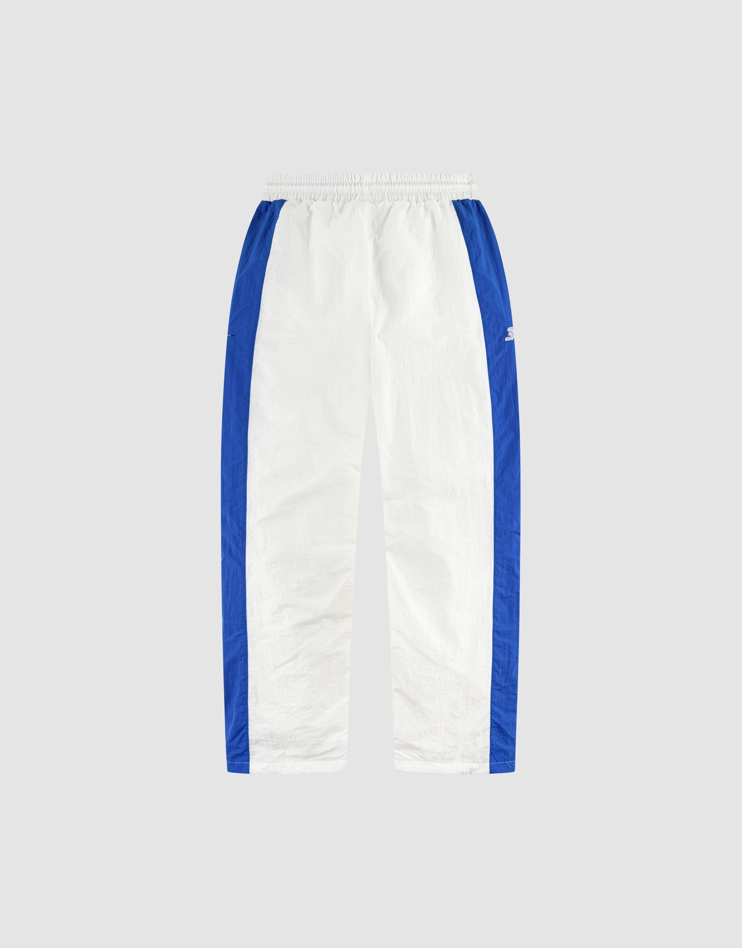 The LFDY Trackpants 3000 by LIVE FAST DIE YOUNG are white with vertical blue side stripes, feature an Elastikbund and Wide Fit, and are displayed on a light gray background.
