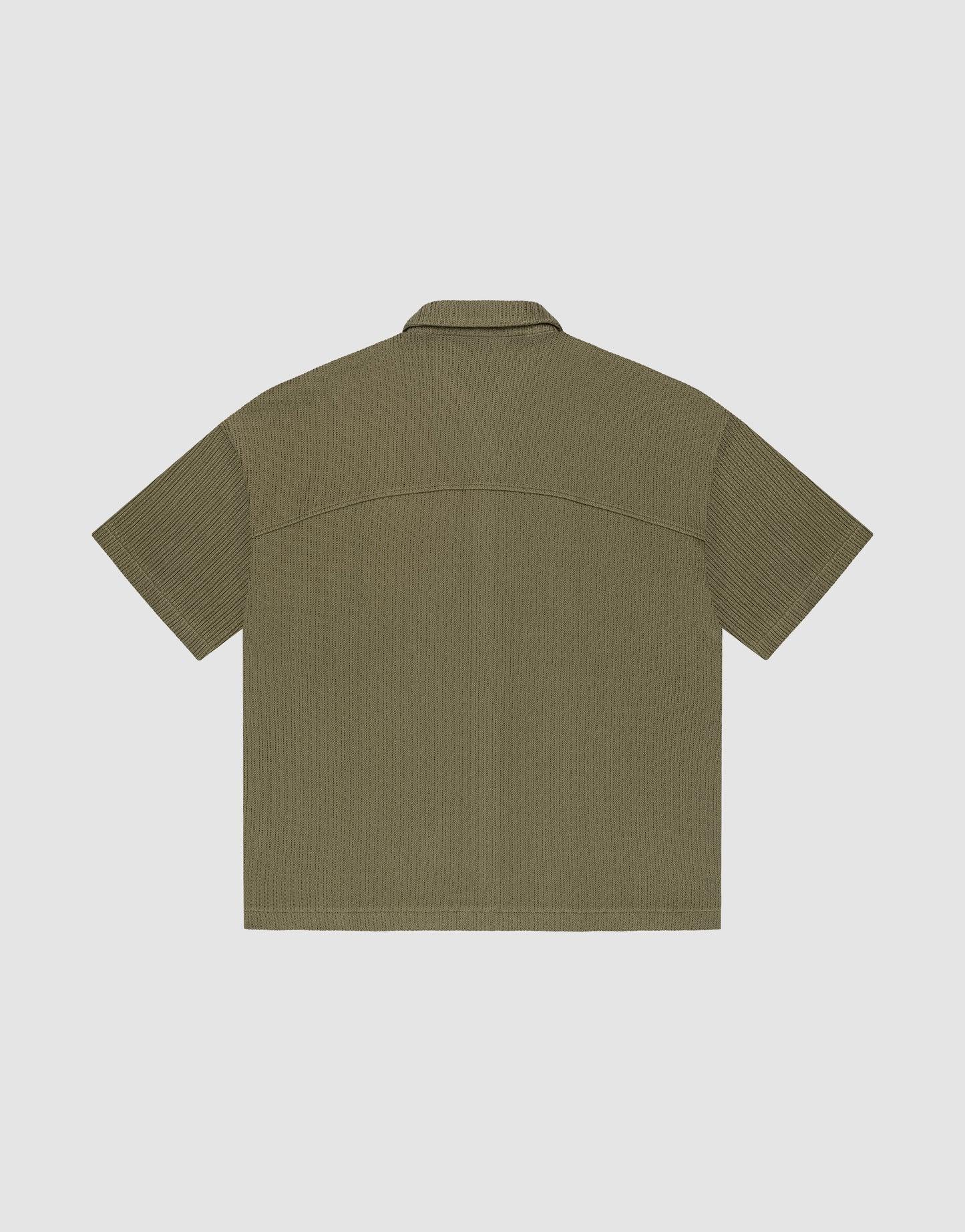 The LIVE FAST DIE YOUNG Basic Knit Shirt, shown flat from the back, is short-sleeved and olive-green with a subtle vertical texture, oversize fit, straight hem, and a simple collar.