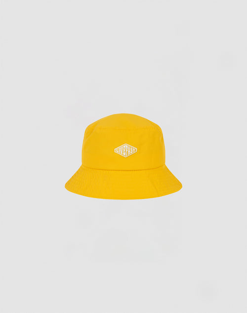 A bright yellow Nylon Bucket Hat from LIVE FAST DIE YOUNG features a small white and gold STAYCASS patch on the front. The hat is centered against a plain light gray background.