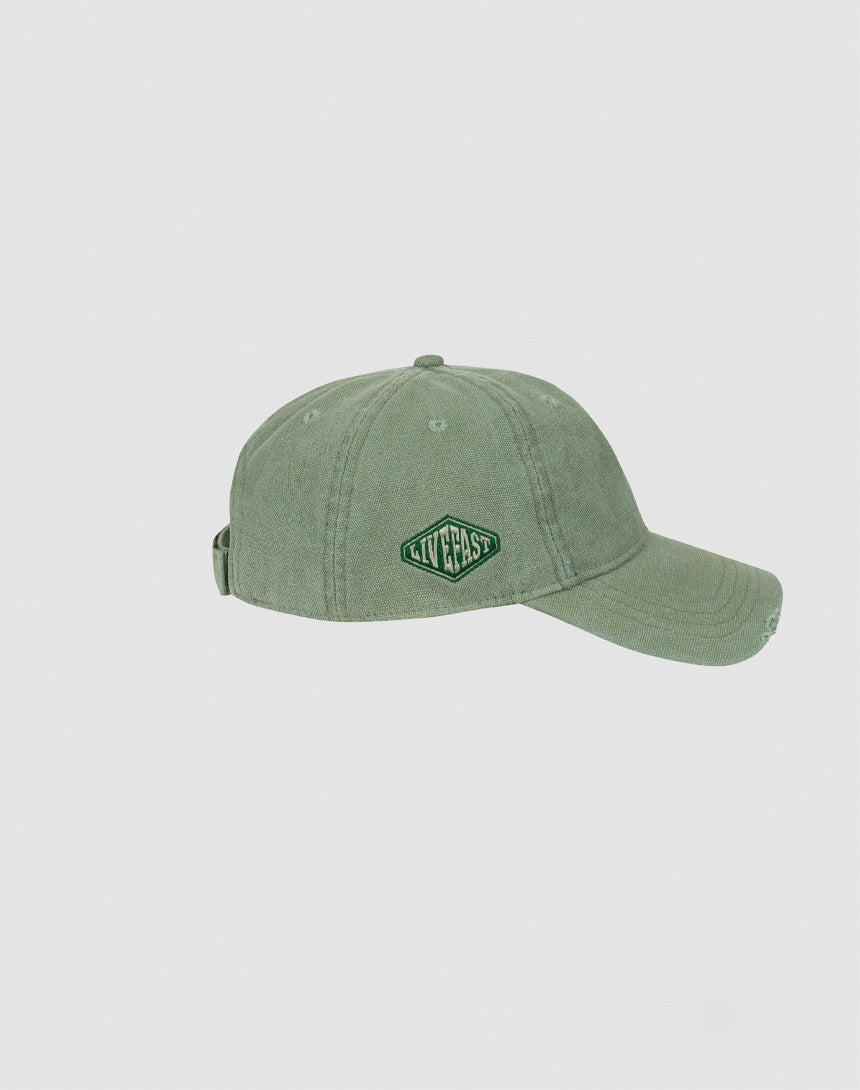 The Distressed Basic Cap by LIVE FAST DIE YOUNG is a 100% cotton sage green baseball cap with a curved brim, adjustable back strap, and a front diamond-shaped green and white LIVEFAST embroidered patch.