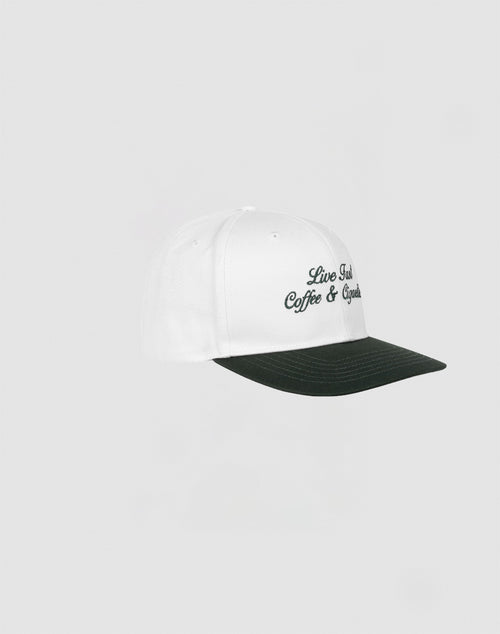 The Live Fast Coffee Cap by LIVE FAST DIE YOUNG features a white design with a dark green brim and black Live Fast Coffee & Cycles embroidery, inspired by the LFDY Berlin Café. Made from 100% Baumwolle, one size, shown on a light background.