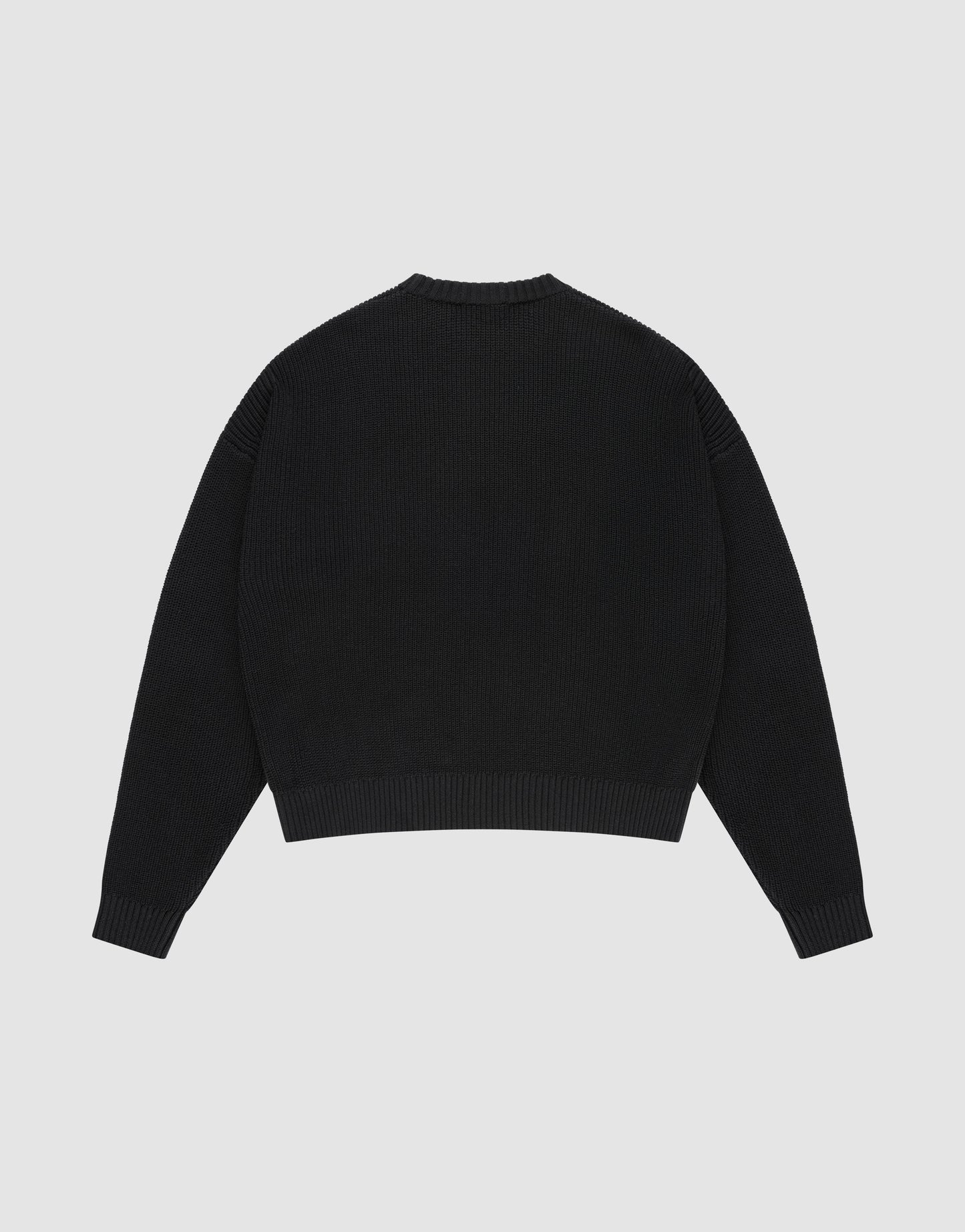 The LFDY Knit Sweater by LIVE FAST DIE YOUNG is a plain black, oversized long-sleeve with a crew neckline, dropped shoulders, and ribbed cuffs and hem. Made from 100% Baumwolle, it's shown laid flat back-up on a light gray background.