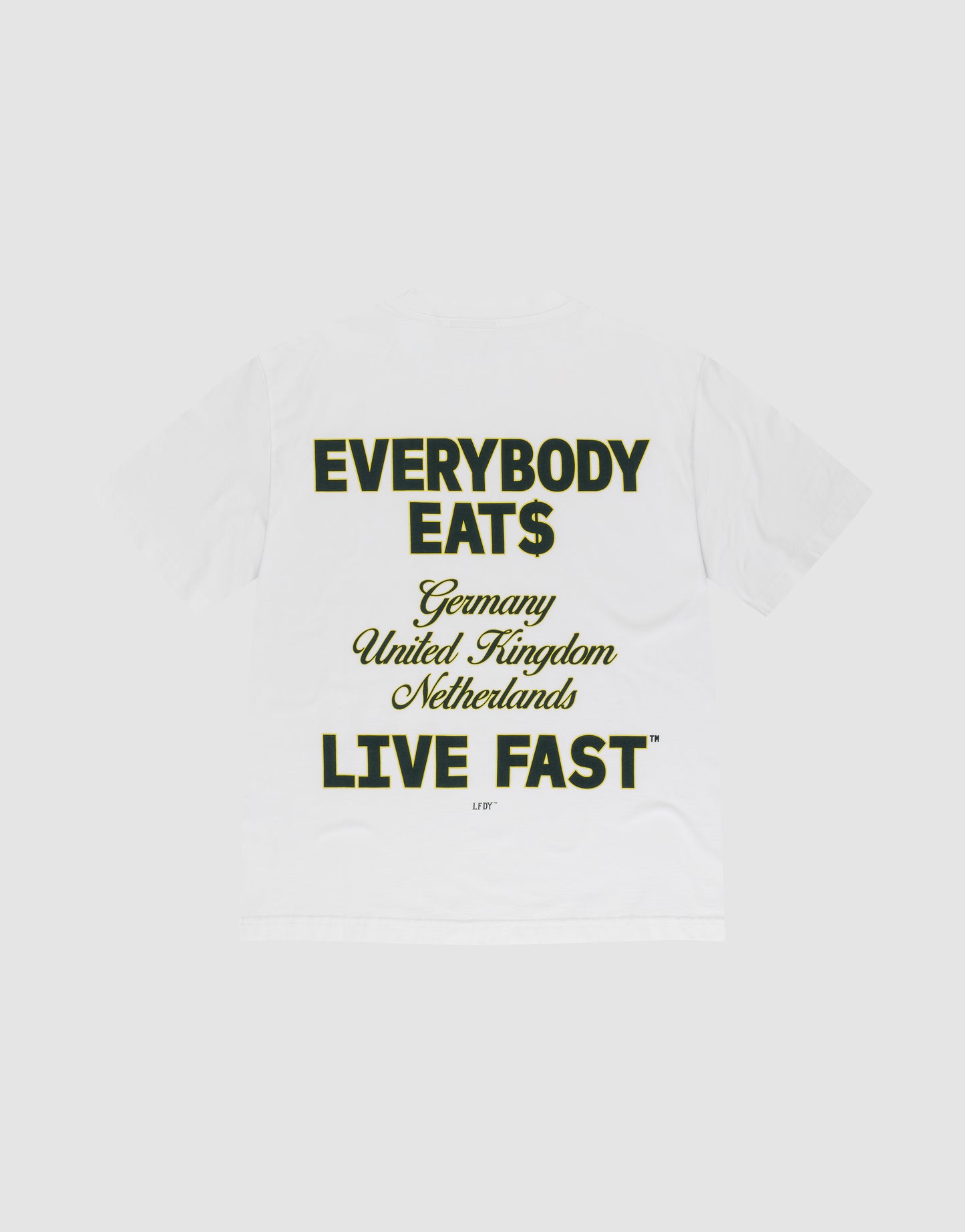 The Everybody Eats Tee by LIVE FAST DIE YOUNG is a white oversized cotton T-shirt with bold black and yellow front and back prints reading "EVERYBODY EAT$ Germany United Kingdom Netherlands LIVE FAST™," shown flat on a light gray background.