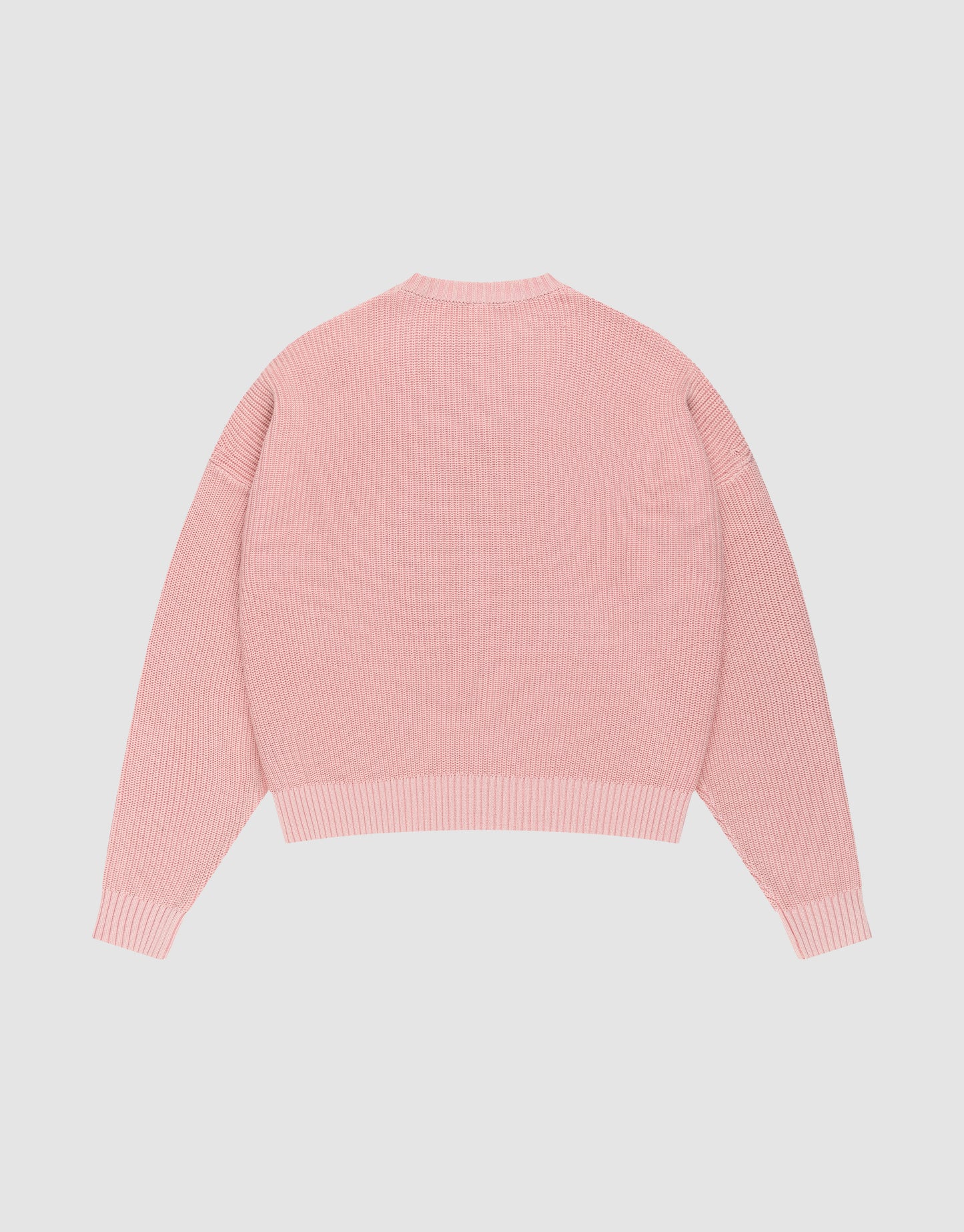 The LFDY Knit Sweater by LIVE FAST DIE YOUNG, in light pink with long sleeves, ribbed knit, oversized fit, and dropped shoulders, is laid flat on a plain white background with the back facing up.