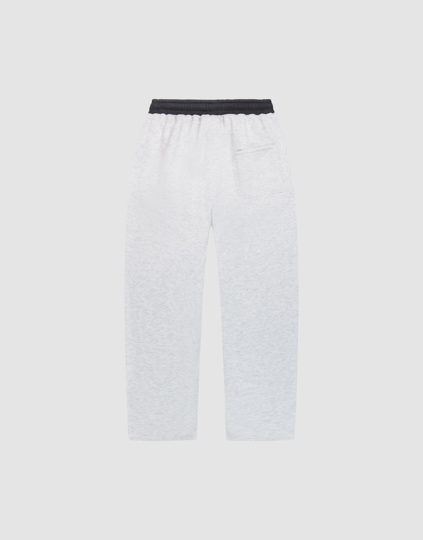 The LFDY District Jogger by LIVE FAST DIE YOUNG, featuring wide-fit white sweatpants with 65% cotton, a black elastic waistband, side pockets, and a back patch pocket, is displayed flat on a plain light gray background.