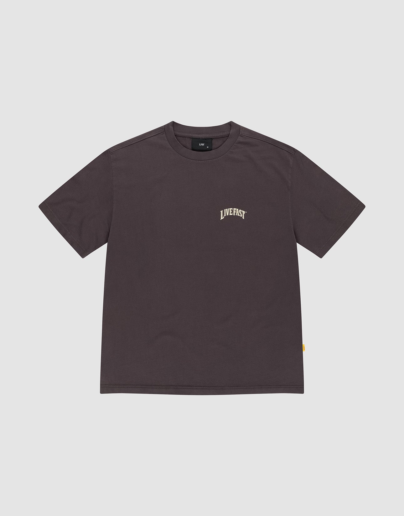 The LFDY x The Bulldog Tee by LIVE FAST DIE YOUNG is a plain dark brown oversized short-sleeve shirt made from 100% Baumwolle, featuring "LIVEFAST" in small, light letters on the left chest, shown on a light gray background.