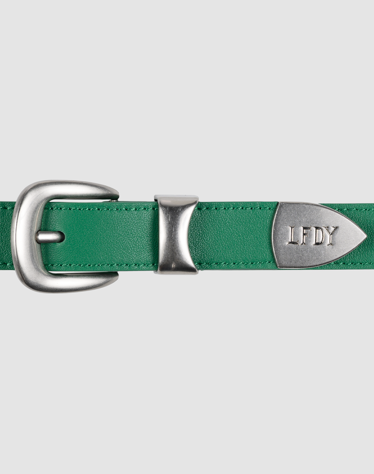 The LFDY Slim Belt by LIVE FAST DIE YOUNG is a green Leder belt (LF2606-20551) with a silver engraved LFDY buckle and tip, shown on a light gray background. Its Gesamtlänge makes it easy to style with any outfit. | model