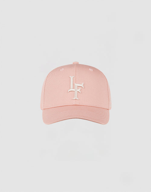 The LF Snapback by LIVE FAST DIE YOUNG is a light pink Baumwolle cap with a curved brim, white embroidered intertwined L and F on the front, and a practical snap closure, shown against a plain light background.