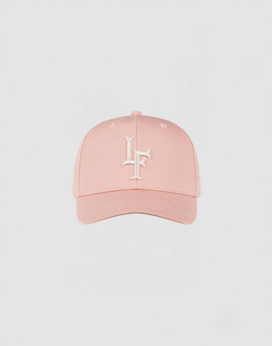 The LF Snapback by LIVE FAST DIE YOUNG is a light pink Baumwolle cap with a curved brim, white embroidered intertwined L and F on the front, and a practical snap closure, shown against a plain light background.