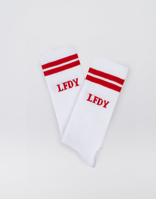 The LFDY Logo Socks (2 Pack) by LIVE FAST DIE YOUNG feature a soft Baumwolle blend with Elastan and Polyamid, two red stripes near the top, and red LFDY embroidery. Shown flat on a white background.